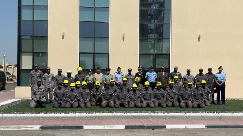 Photo de groupe des forces de sécurité intérieure. Photo prise de jour, en extérieur, devant un batiment beige.