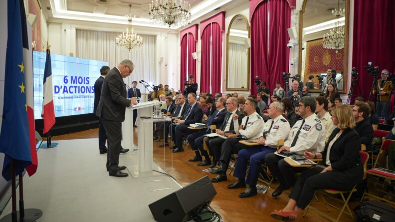 Agrandir l'image Le ministre de l'Intérieur, de profil, debout derrière un pupitre, face à une salle rassemblant des autorités civiles et militaires, ainsi que des journalistes.