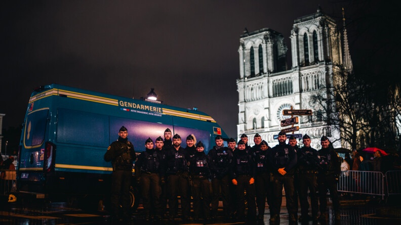 Un vingtaine de gendarmes posent devant leur v&eacute;hicule. En fond on aper&ccedil;oit la cath&eacute;drale.