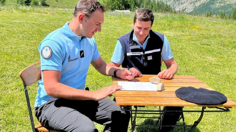 Nils Allegre est attablé avec le commandant du PGHM. Il signe la convention de parrainage.