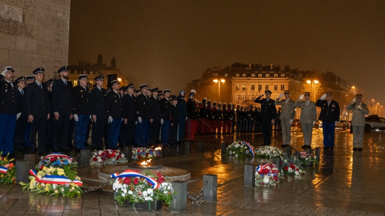 Des troupes en rag autour de la tombe du soldat oincconu, de nuit sous la pluie. les autorit&eacute; saluent