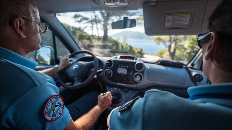 En voiture, deux gendarmes de l'armement réalisent une patrouille pour s'assurer qu'aucune intrusion ne vienne mettre en péril la sécurité de l'ile et des personnels.