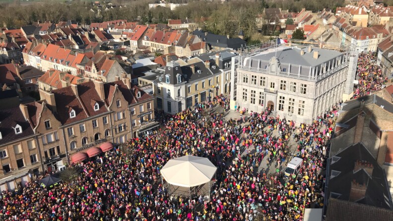 La photo repr&eacute;sente une foule de carnavaleux mass&eacute;s devant l'h&ocirc;tel de ville de Bergues, lors du carnaval du 30 mars 2025.