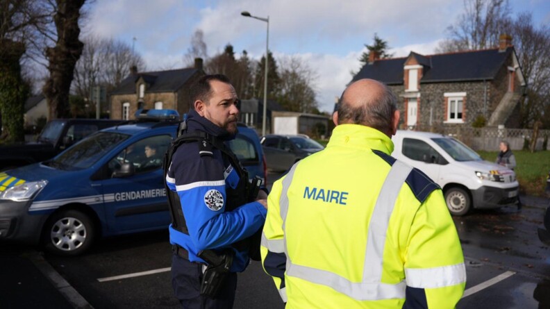 Un gendarme &eacute;changeant avec un maire.