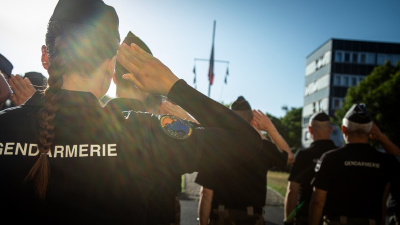 Agrandir l'image La photo représente un groupe de militaires, debout, de dos, effectuant le salut militaire