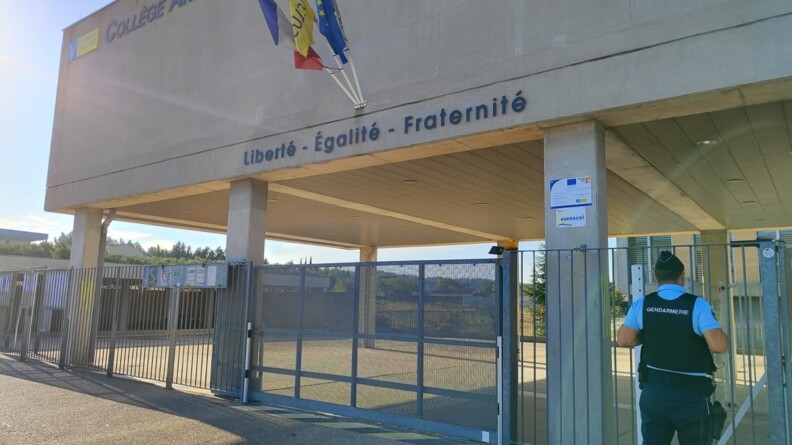 Agrandir l'image Devant un lycée en béton, à droite, un gendarme devant les grilles