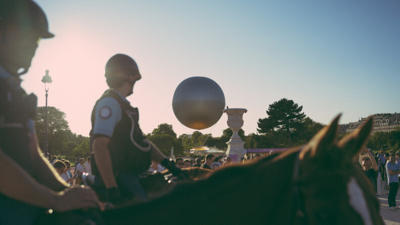 Deux cavaliers de la gendarmerie devant la vasque des JO.