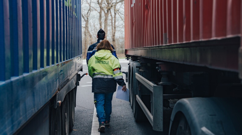 Un gendarme et une agent des douanes entre deux camions