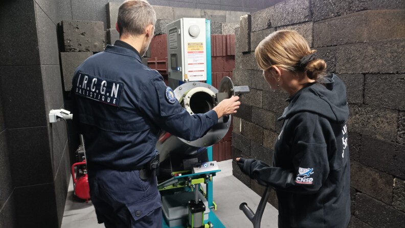 La para-sportive Gaëlle Edon, Sportive de haut-niveau de la Défense - Gendarmerie (SHND-G), à gauche, de dos, avec à sa gauche un expert du département ballistique de l'Institut de recherche criminelle de la gendarmerie nationale.