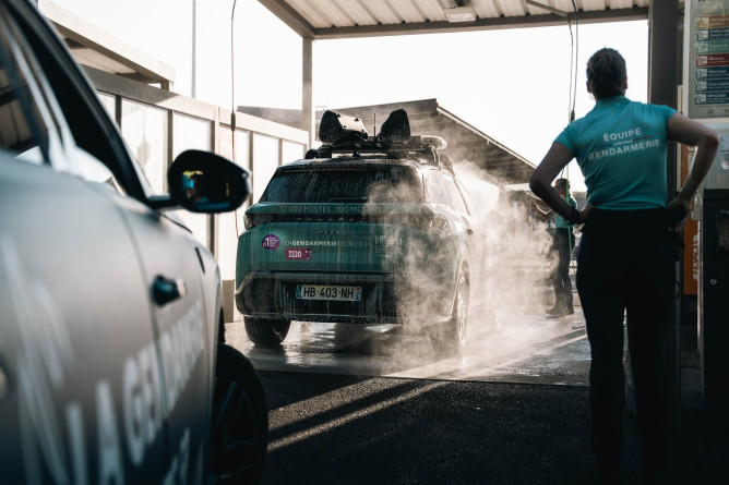 Agrandir l'image Gendarme nettoyant un véhicule de la caravane après course.