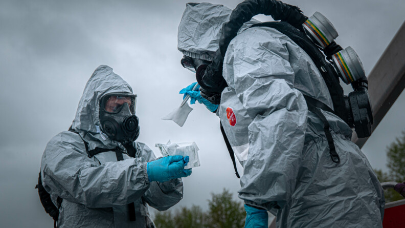 Le médecin IRCGN et un opérateur NRBC procèdent à des analyses scientifiques sur la péniche