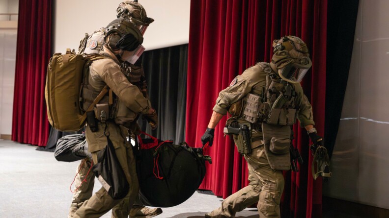 Trois hommes du GIGN ransportent un homme dans une civi&egrave;re