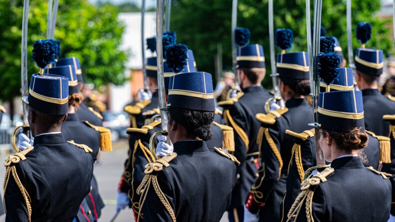 Des &eacute;l&egrave;ves officiers de la gendarmerie de dos saluent au sabre