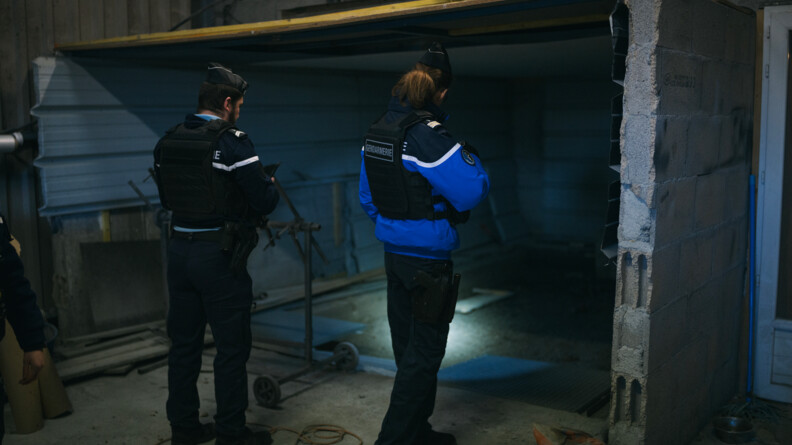 Agrandir l'image Deux gendarmes de dos fouillant une cave