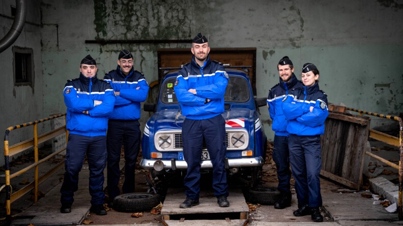 Cinq officiers de gendarmerie devant et autour d'un 4L gendarmerie dans un garage de fortune