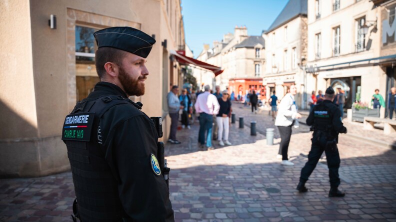 Un gendarme en premier plan avec derrière, en flou les rues de Bayeux et la foule de visiteurs venus assiter aux cérémonies.