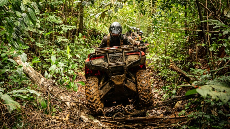 Militaire roulant sur un ensemble de branches avec son quad.