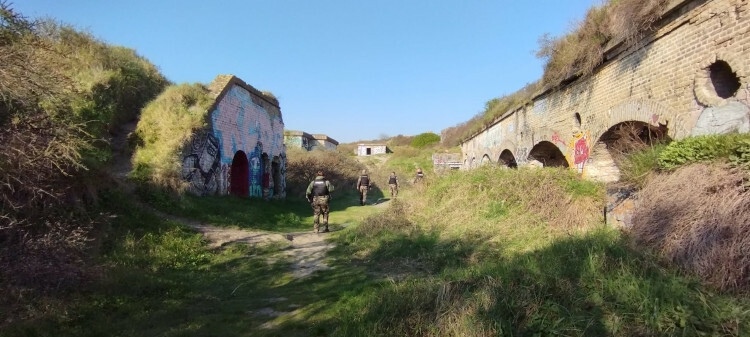 Sous un ciel bleu, quatres gendarmes réservistes recherchent dans les dunes de potentiels migrants prévoyant de traverser la Manche en direction de la Grande-Bretagne.