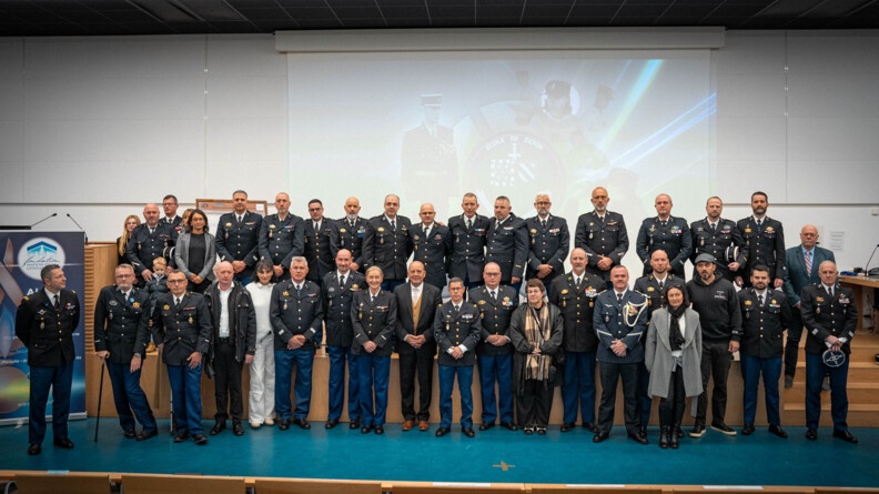 De nombreux militaires de la gendarmerie nationale, bless&eacute;s en service, posent en uniforme bleu marine, les uns aux c&ocirc;t&eacute;s des autres, sur une estrade. Au milieu du groupe se tient le Major g&eacute;n&eacute;ral de la gendarmerie nationale