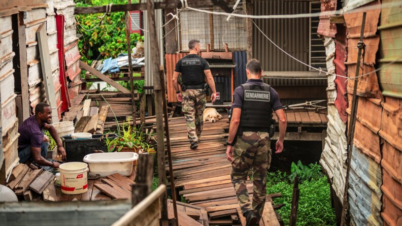 Agrandir l'image Gendarmes de la compagnie de Matoury de dos dans un quartier informel.