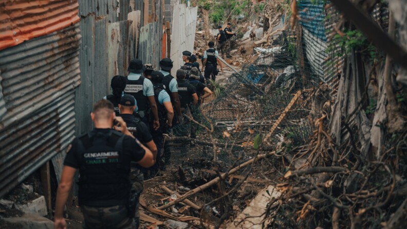 La d&eacute;l&eacute;gation du DGGN marche au milieu des ruines et des bouts de t&ocirc;les.