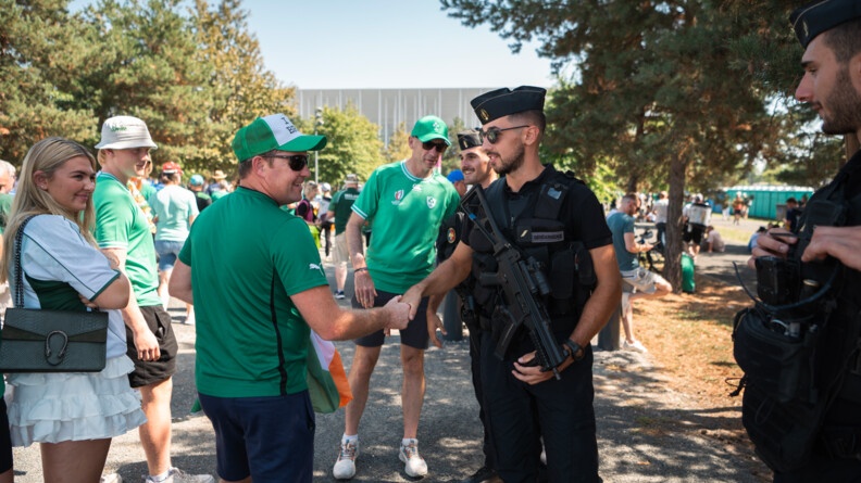 Un supporter irlandais serre la main d'un gendarme mobile. Autour d'eux, deux autres gendarmes et trois autres supporters souriants.