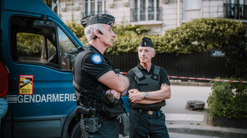 Devnat un irisbus, un lieutenant-colonle de gendarmeire discute avec un aumônier portestant dans la rue