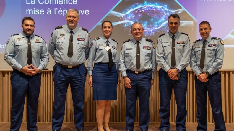 Agrandir l'image 6 gendarmes en tenue chemise cravate, dont une femme (la 3e à partir de la gauche), sourient devant un écran mentionnant "la confiance mise à l'épreuve"