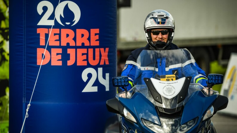 Motard de la Garde républicaine à l'arrivée d'une étape devant le logo Terre de jeux 2024