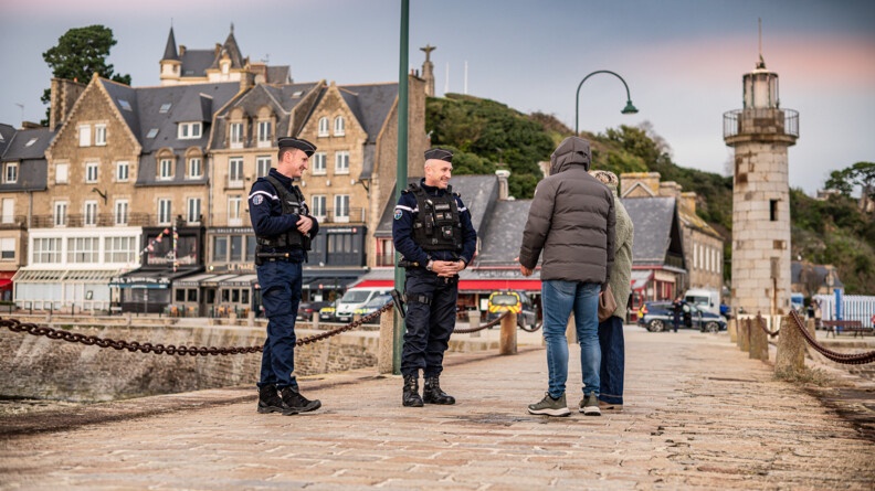 Agrandir l'image Deux gendarmes parlent avec deux personnes sur un pont dans une ville bretonne