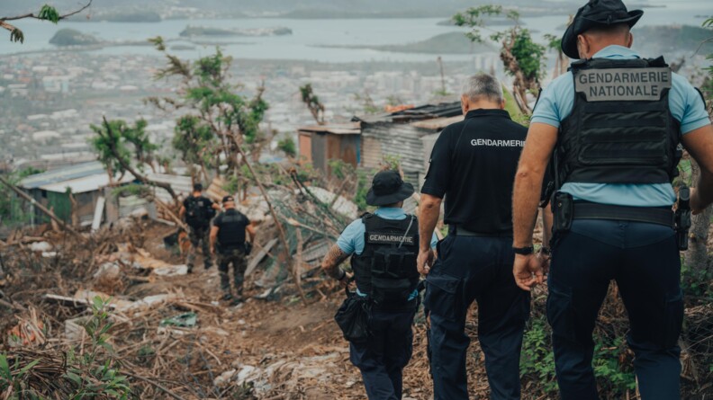 Les gendarmes et le DGGN se rendent sur une zone sinitr&eacute;e par l'ouragan. En fond, se trouve la mer et la ville qui s'&eacute;tend.
