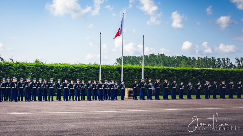 Agrandir l'image une promotion d'élèves-gendarmes en vareuse rassemblée, de part et d'autre du mât du drapeau français