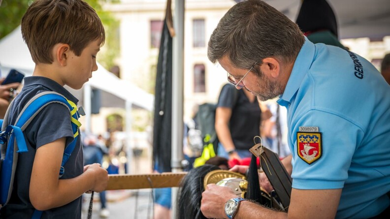 Agrandir l'image Un enfant obesrve un gendarme de la Garde républicaine avec son casque de cavalerie.
