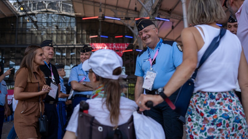 Agrandir l'image Le directeur général de la gendarmerie nationale, présent au Club France, sourit aux personnes présentes, que l'on aperçoit de dos.