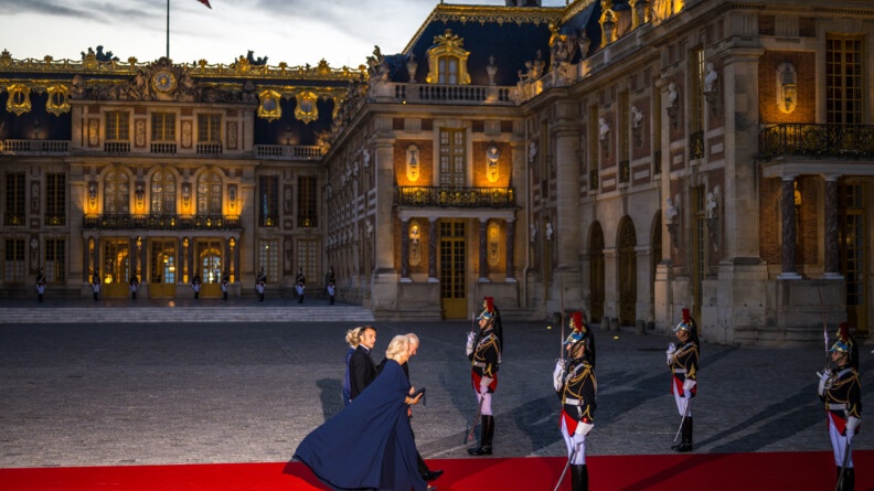 Le couple royal et le couple présidentiel, entre ensemble dans le château de Versailles, entourés de militaires de la Garde Républicaine.