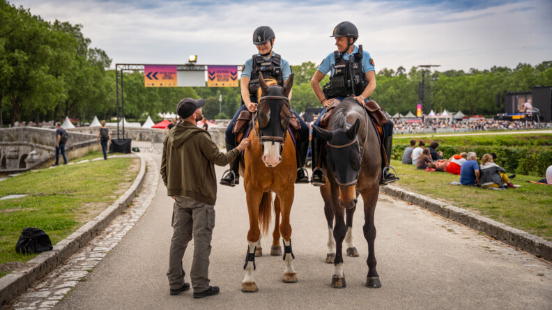 Agrandir l'image Deux gendarmes à cheval échangent avec un spectateur autour du château de Chambord.