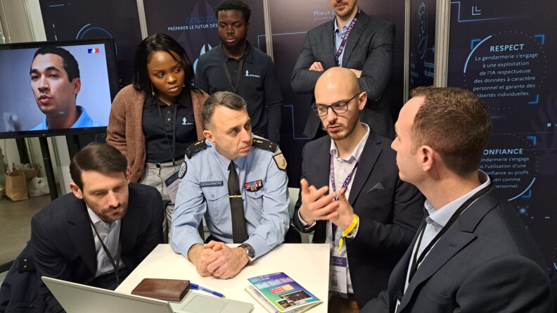 Le général de brigade Patrick Perrot, chef du Service transformation (ST) de la Direction générale de la gendarmerie nationale (DGGN), et coordonnateur national de l’IA au sein de la gendarmerie, échange avec des industriels au World Artificial Intelligence Cannes festival (WAICF), autour d'une table sur le stand de la gendarmerie nationale.