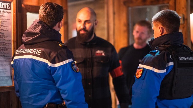 Deux gendarmes échangent avec un agent de sécurité à la sortie d'une boite de nuit.