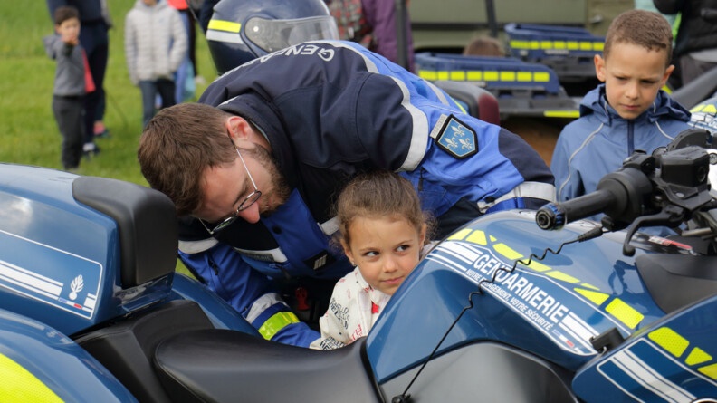 Agrandir l'image Un gendarme aide une petite fille à monter sur une moto gendarmerie