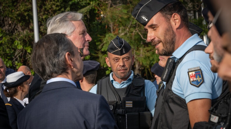 Le Premier ministre, Michel Barnier, accompagn&eacute; du minsitre de l'Int&eacute;rieur, Bruno Retailleau, se tenant de dos sur la photo, discute avec des gendarmes