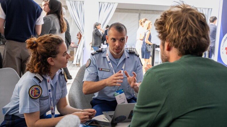 Gendarmes &eacute;changeant avec des participants de la 6e &eacute;dition de la Rencontre des entrepreneurs de France (REF) &agrave; l&rsquo;hippodrome Paris-Longchamp.