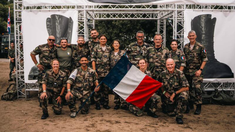 Agrandir l'image Un groupe de militaires, en trellis kaki, posent en tenant dans leurs mainsun drapeau français