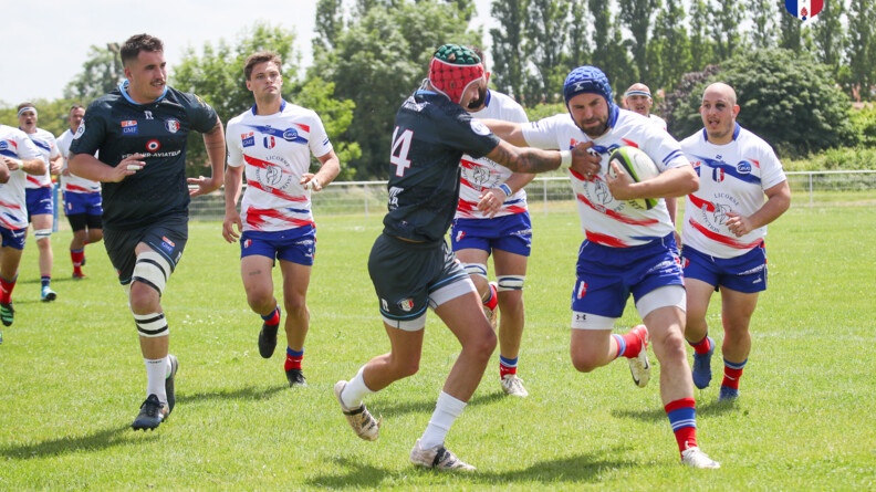 Agrandir l'image Un rugbyman de la gendarmerie raffute un adversaire de l'armée de l'air et de l'espace tandis que les coéquipiers se dirigent vers leurs camarades