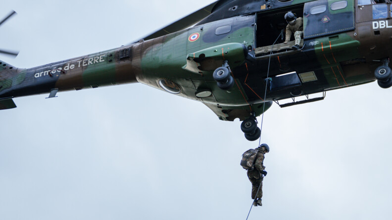Un gendarme du GIGN descend en corde lisse depuis un Puma du GIH, sous le regard d'un autre militaire embarqu&eacute;.