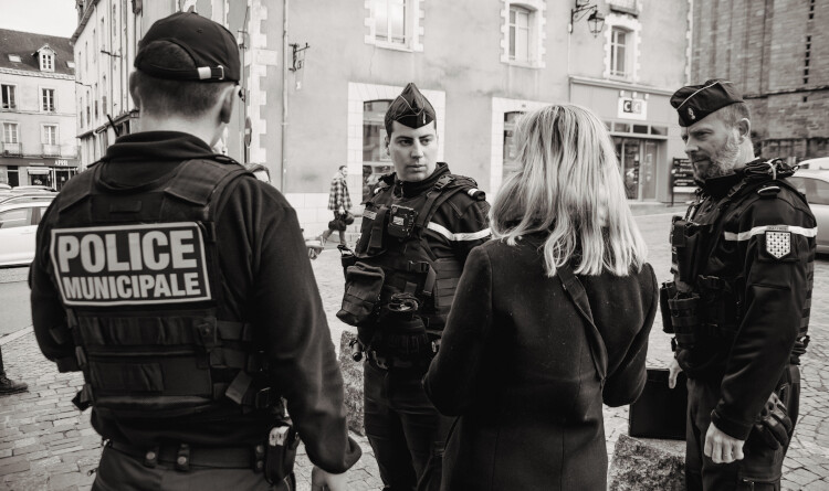 Agrandir l'image 2 gendarmes et un policier discutant avec une femme de dos.