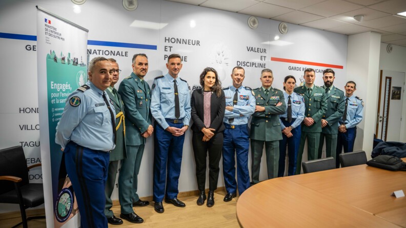 Dans une pièce aux murs blancs, recouvertes d'inscriptions diverses (valeur et discipline, Garde républicaine...), posent debout onze personnes, soit neuf hommes et deux femmes, en tenue militaires bleues et vertes (à l'excpetion d'une personne civile). derrière eux, on aperçoit un kakémono portant l'inscription "Engagés pour l'environnement et la santé".