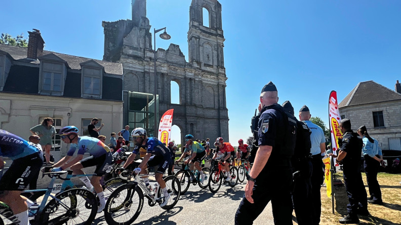 Peloton de coureurs cyclistes passant devant les gendarmes