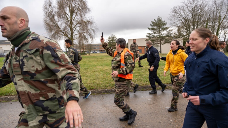 Gendarmes et policiers protègent le porteur d'une flamme olympique fictive lors d'un exercice.