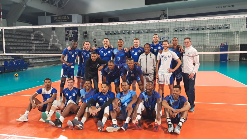 Agrandir l'image Un groupe de sportif debout et assis devant u filet de voleyball dansun gymnase