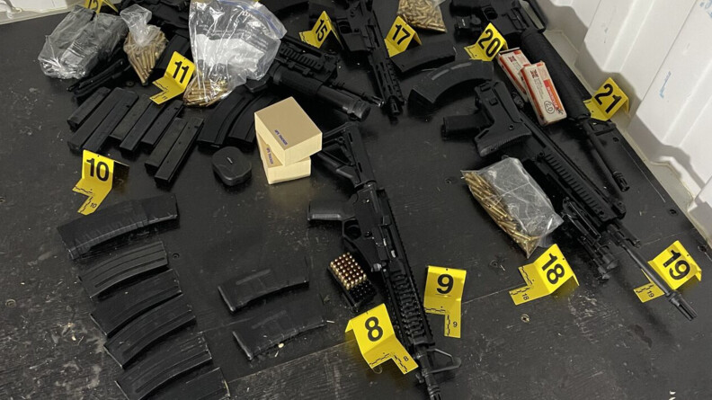 Agrandir l'image cinq armes d'épaule et munitions accompagnés de numéros de preuves sur un sol noir